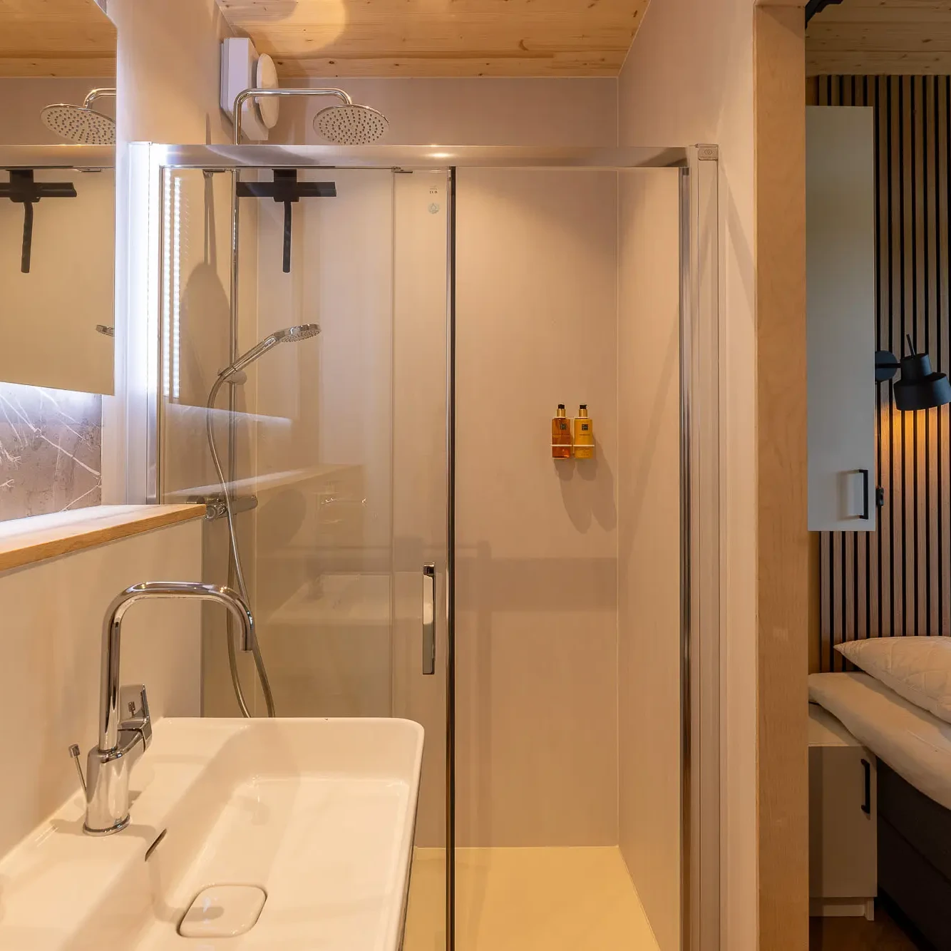 Moderne badkamer met inloopdouche en slaapkamer in luxe Panorama lodge Markelo