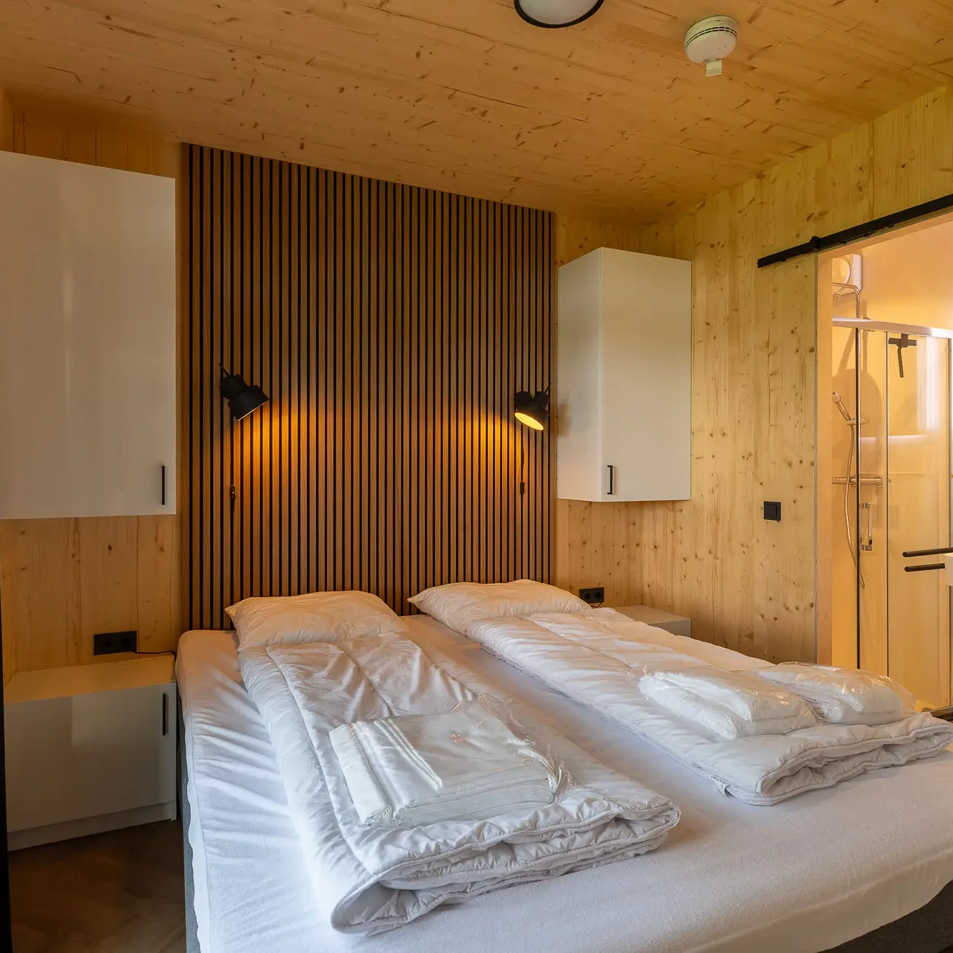 Luxe slaapkamer met houten interieur en en-suite badkamer in Panorama Lodge Markelo