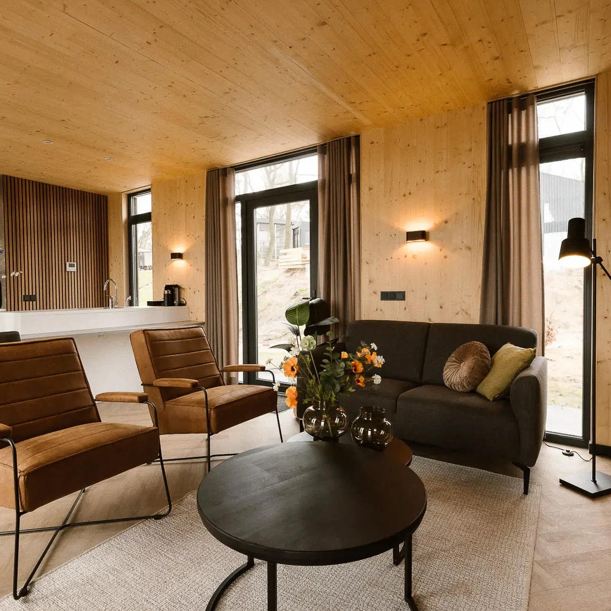 Luxe woonkamer met houten wanden en plafond in Panorama Lodge Markelo
